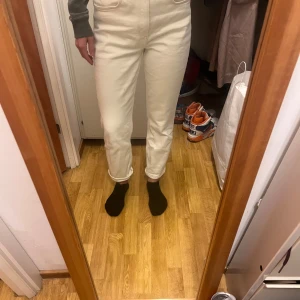 Vita slim jeans från H&M - Säljer ett par vita slim jeans från H&M i storlek 38. De är högmidjade och har en vintage stil. Perfekta för en stilren look.