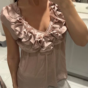 Rosa blus med volangdetaljer - Säljer en söt rosa blus med volangdetaljer!