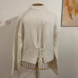 Vit stickad tröja med snörning - Populär typ av tröja, stickad med knytning i midjan. As snygg   !!!Många intresserade så säljer bara vid snabb affär och till fullpris