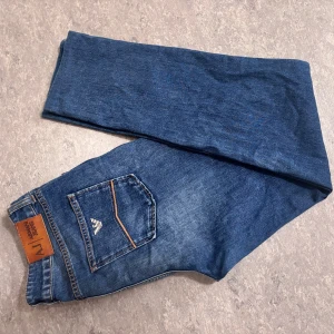 Blå jeans från Armani Jeans - Snygga blå jeans från Armani Jeans med klassisk femficksdesign och logotypdetalj på bakfickan. Perfekta för en stilren look. Size 30/30 slimfit 