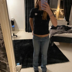 Svart t-shirt med Converse-logga - Snygg svart t-shirt från Converse med den klassiska loggan på bröstet. Perfekt för en avslappnad stil.