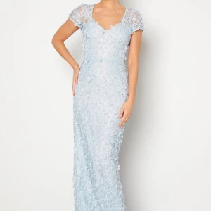 Ljusblå spetsklänning från Ida Sjöstedt - Elegant ljusblå långklänning i spets från Ida Sjöstedt. Klänningen har kortärmade spetsärmar och ett vackert blommigt mönster. Perfekt för speciella tillfällen med sin romantiska design och fina detaljer.Helt ny med lappar kvar, nypris 7.999kr