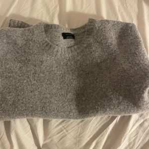 Grå stickad tröja från Massimo Dutti - Mysig grå stickad tröja från Massimo Dutti i alpacka och ullblandning. OBS den krympte i tvätten, den var M(herr) ursprungligen, men skulle uppskatta att det är en xs(herr) eller s/m(dam) storlek nu. Mer eller mindre oanvänd men krymptes första tvätten
