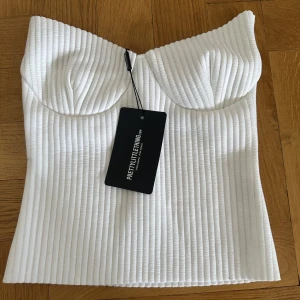Topp - Säljer denna oanvända topp från Prettylittlething🤍 Toppen är tyvärr för liten för mig så jag har inga bilder hur den sitter ut på.