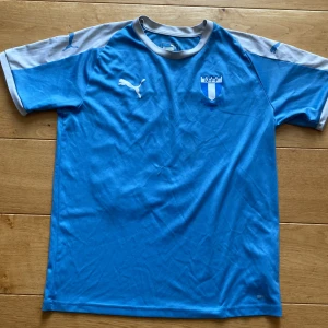 Fotbollströja  - En Malmö FF tröja med Christiansen på ryggen i st 13-14 år. Tröjan är i mycket fint skick förutom att ett av numrera ha släppt lite!