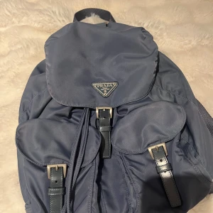 Prada ryggsäck  - Säljer då den tyvärr är lite för de jag behöver den till, väldigt bra skicka men lite solblekt på ena sidan (sista bilden) däremot är det ingen man tänker på och syns egentligen bara när man lyser på de. Certifikat och allt sånt ingår självklart!