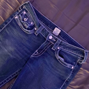 Mörkblå jeans med vita sömmar - Säljer ett par snygga mörkblå jeans med kontrasterande vita sömmar. Jag älskar dom här men, Säljer dom för dom inte riktigt kommer till användning och ja vill köpa ett par andra jeans. Dom är inte jätte använda och i bra skick men dom är lite slitna 