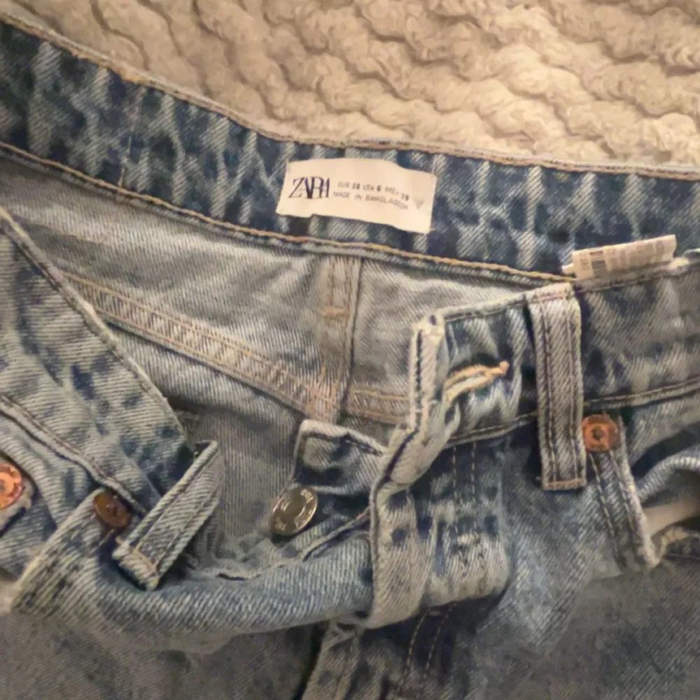 Ljusblåa jeans från Zara med hål i de är i stl 38 men små i storlek.  aldrig använda bara testade hål längst nere vid benet (sista bild) ska vara så så ingen defekt men så ni vet att det ser ut så. Jeans & Byxor.