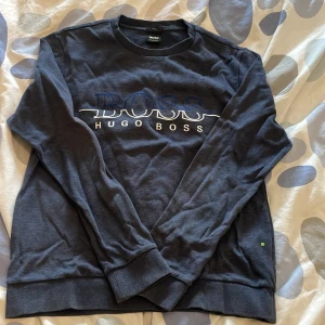Hugo boss sweatshirt - Denna jätte fina Hugo boss sweatshirt användes inte längre och är i väldigt bra skick de ända dåliga är att det har blivit ett håll där ner på tröjan men som knappt märkes och har blivit sytt