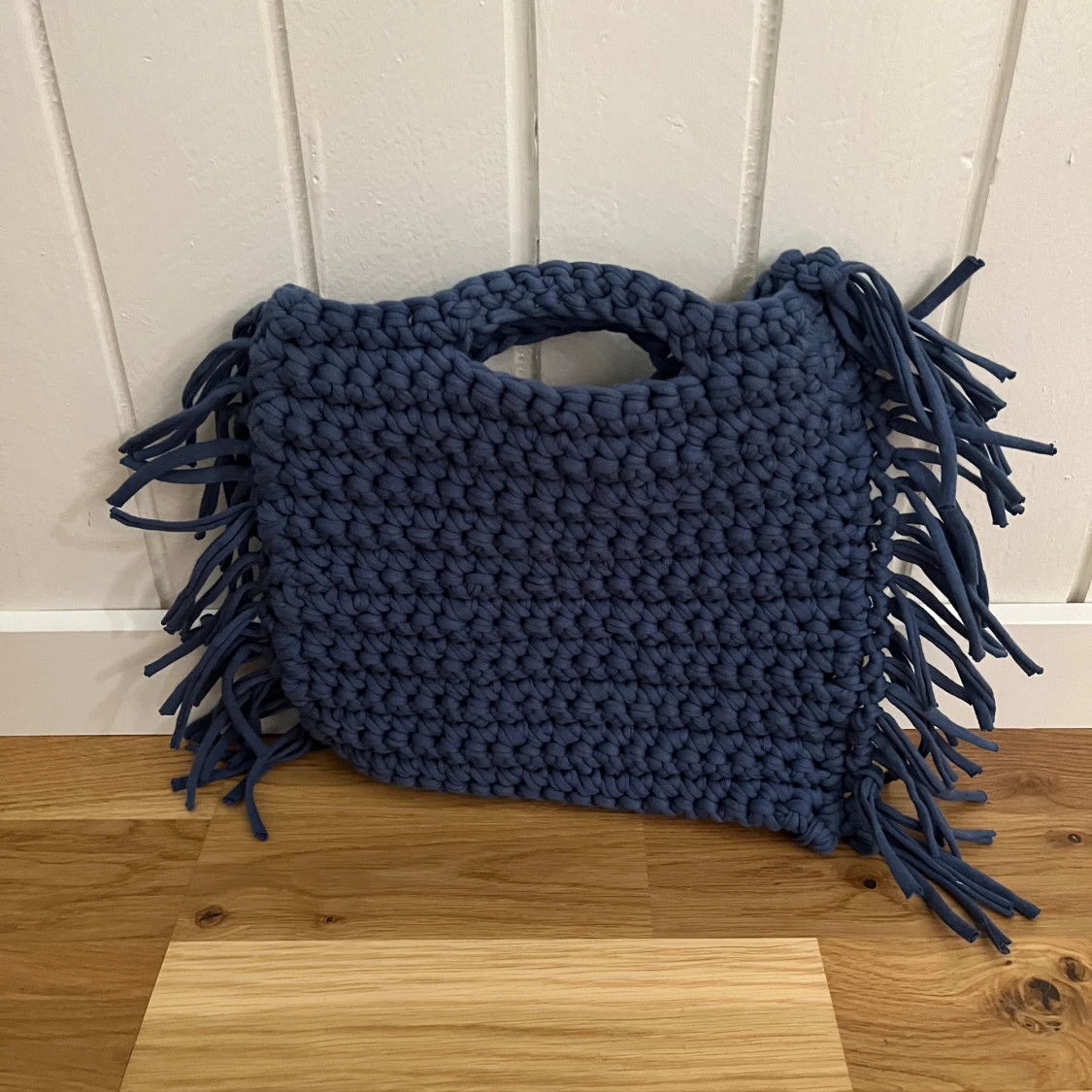 Blå stickad väska med fransar