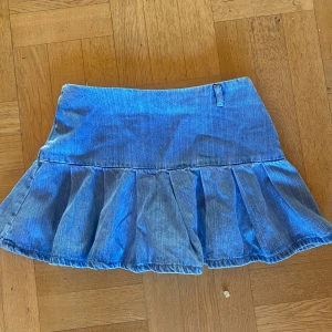 Blå jeanskjol med volang - Säljer en superfin blå jeanskjol med volangdetaljer. Kjolen har en dragkedja på sidan för enkel på- och avtagning. Perfekt för en avslappnad sommarlook eller en dag på stan. Passar bra till allt!! Finns ingen lapp, uppskattar till storlek S och har inga defekter 😌💗