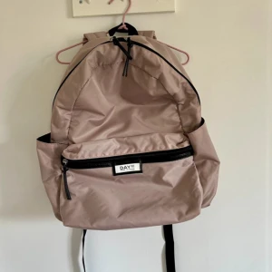 Day Gweneth RE-S BP B - ryggsäck  - Säljer min ryggsäck från Day Et i färg cloud rose/rose, köpt 2024. Använd endast en gång, har ingen användning för den längre. Original pris - 849kr.  Mått: H: 41cm / W: 30cm / D: 18cm Vikt: 0.3kg