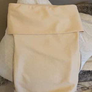 Beige topp från Zara - Säljer en stilren beige topp från Zara. Den har en praktisk dragkedja och är perfekt för fest. Tillverkad i ett mjukt material som känns både hållbart och bekvämt. Passar perfekt för både utgång och fritid!