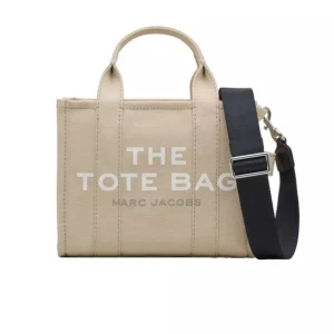 Marc Jacobs Tote Bag S - Marc jacobs tote bag i beige i stl Small. Tillkommer en svart axelrem. Knappt använd, köpt för 2,6. Inga skavanker eller fläckar. Säljer pga den ej kommer till så mycket användning. Flexibel i pris vid snabb affär