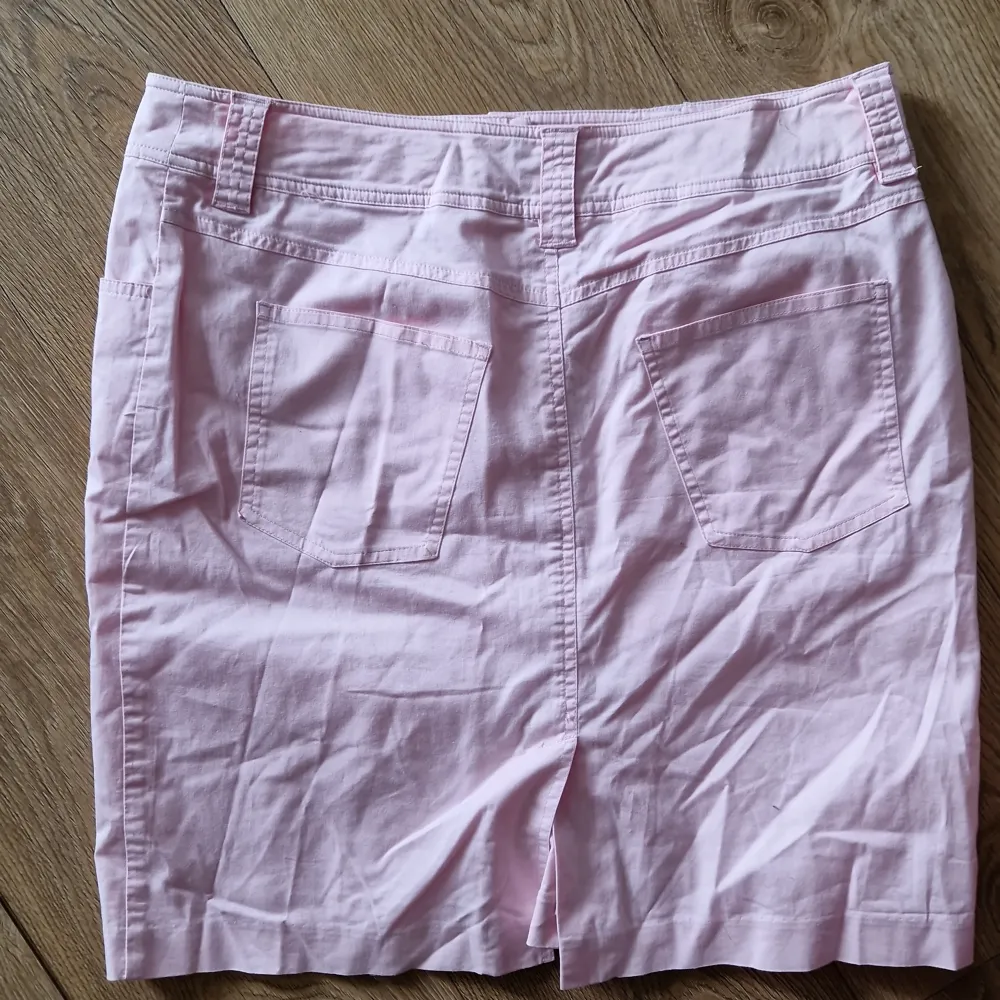 Säljer en söt rosa kjol från Joy i storlek 40. Kjolen är i en mjuk bomullsblandning med 1% elastan för lite stretch. Den har en klassisk design med fickor fram och bälteshällor. Perfekt för vår och sommar!. Kjolar.