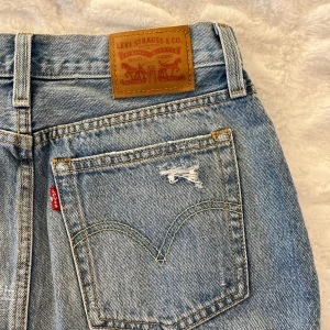Levi’s Jeans Kjol 💙 - Säljer denna fina jeanskjolen i nyskick från Levis eftersom den inte kommer till användning🫶🏼 Storlek 25 (ungefär XS) och slits nedertill med bak och framfickor. Vid intresse/fler bilder är det bara att skriva🤍