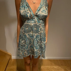 Unik klänning - Säljer denna otroligt fina klänningen som är köpt i Palma. Skulle säga att den passar allt i från en xs till m då det går att justera banden, längden och midjan är i töjbart tyg