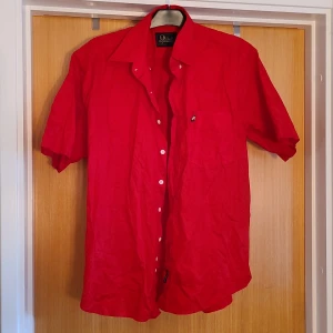 Peak Performance-skjorta - Röd, kortärmad peak performance-skjorta. Fint skick. Lite tjockare men inte supertjock material.