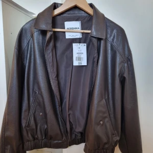 Skinnjacka storl S - Jacka i skinnimitation från Bershka, är storlek S. Perfekt för hösten! Kom aldrig till användning, så endast testad och är helt som ny! Köptes för 600kr (den bruna verkar inte säljas längre därav är de två sista bilderna på en svart variant)