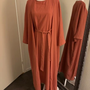 Klänning / abaya  - Helt ny, str S   Den är en inner klänning som kan användas för sig själv och så tillkommer det en abaya till den . Redan nedsatt pris ! 