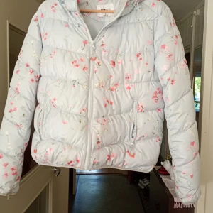 Jacka med luva blommig Stl L - Fin jacka med blommor o luva stl L.i nyskick.