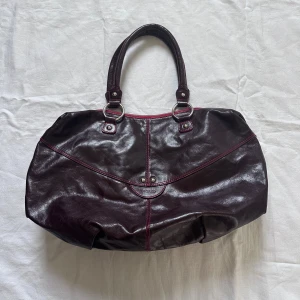 Väska  - Medelstor väska i brunt läder med röda detaljer  28x45cm Vid köp av flera varor får du rabatt 💛