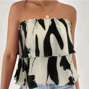 Svartvit axelbandslös topp - Säljer en superfin svartvit axelbandslös topp med ett abstrakt mönster. 