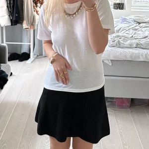 Svart stickad kjol från Zara - Säljer en superfin svart stickad kjol från Zara storlek S. Den är kort och har en skön, loose passform som passar perfekt till både vardag och fest. Kjolen är i mycket bra skick och är perfekt för höst och vinter. Den är enkel att matcha med olika toppar och accessoarer. Perfekt för att skapa en stilren look!