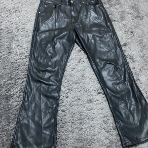 Svarta skinnbyxor från Perfect Jeans Gina tricot - Säljer ett par svarta skinnbyxor från Perfect Jeans i storlek 40. Byxorna har en klassisk femficksdesign med knapp och dragkedja framtill samt låg midjade. Perfekta passar både till vardags och fest. Ops bilden framhäver inte hur svarta det är pga av ljus🖤