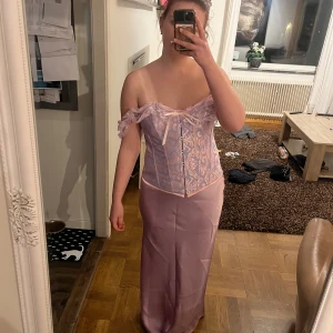Rapunzel kostym - Säljer nu denna kostym då den kom för sent.  Det är en Korsett stl M, kjol stl M, en tiara och blommor man kan ha i håret. Allting är köpt för ca 300kr. Aldrig använd.