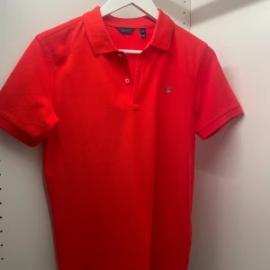 Röd piké kortärmad tröja. Gant.  - Röd piké kortärmad tröja. Gant.  Oanvänd.  Stl 170