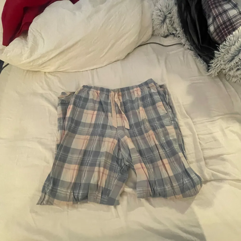 Säljer en superfina rutig pyjamas sett från Victoria's Secret i mjukt material. Pyjamasen har en avslappnad passform med långa ärmar och knappar framtill med ett par mjuka långa pyjamas byxor. Perfekt för en mysig hemmakväll eller sommarens lata dagar. 💙. Skjortor.