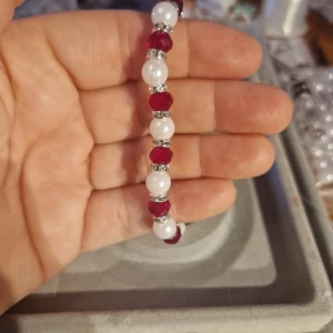 Färgglada pärlarmband - Säljer handgjorda armband med vita pärlor och färgglada detaljer i rött.Armbanden har även små silverfärgade mellanpärlor som ger en extra glittrig touch. Perfekta för att liva upp vilken outfit som helst! Passar bra till både vardag och fest.
