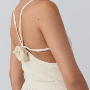 Ecru stickad linnetopp - Säljer en superfin ecru-färgad stickad linnetopp med smala axelband och en söt rosett i ryggen. Toppen är oanvänd och var prislappen kvar