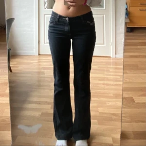 Svarta bootcut jeans med broderi - Säljer ett par svarta bootcut jeans i mycket bra skick. De är lågmidjade och har snygga broderade detaljer på bakfickorna. Bilderna är från förra ägaren och säljer då de var för korta. Om ni undrar över något tveka inte att fråga<3
