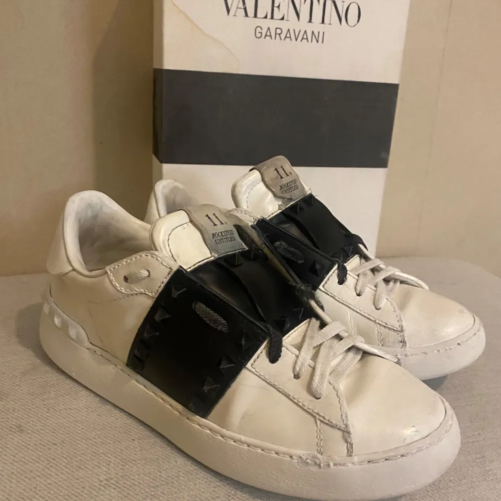 Säljer ett par snygga Valentino Rockstud sneakers i vitt skinn med svarta detaljer. Skorna är storlek 37, passformen är dam men fungerar helt felfritt för män också. Sko boxen har en kaffefläck som jag har råkat spilla😅 Nypris på skorna är på 9500kr. Skor.