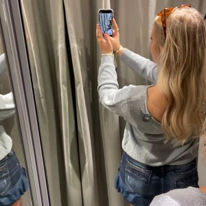 Glittrig grå offshoulder-tröja - Säljer en superfin glittrig grå med lite små pärlor tröja. Den är perfekt för fest med även vardags. Tröjan har långa ärmar och en djupare rygg Perfekt att matcha med jeans eller kjol för en snygg look! Lappen är kvar