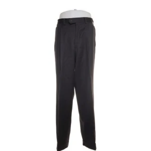 Svarta kostymbyxor från Oscar Jacobson - Snygga svarta kostymbyxor från Oscar Jacobson i klassisk stil. Perfekta för både formella tillfällen och kontoret. Byxorna har en rak passform och är tillverkade i ett elegant material som ger en stilren look. De har knappar och dragkedja framtill för en säker passform.