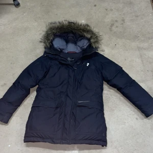 Svart vinterjacka från Peak Performance - Säljer en svart vinterjacka från Peak Performance i storlek S. Jackan har en mysig pälskantad huva och praktiska fickor med dragkedja. Perfekt för kalla vinterdagar! 🖤