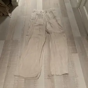 Säljer ett par bekväma och stilrena beige linnebyxor från H&M. De är i storlek S och har en loose passform med elastisk midja för extra komfort. Perfekta för sommarens varma dagar eller en avslappnad vårlook. Byxorna är i bra skick och redo för en ny ägare!💫💕