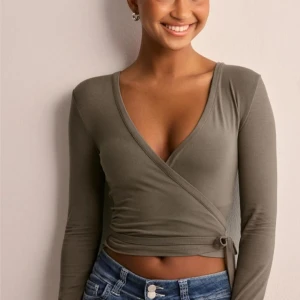 Nelly omlottopp - Snygg omlottopp med lång ärm och knytning i sidan. Perfekt för en stilren look.