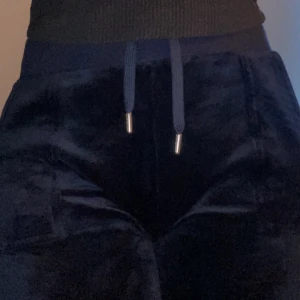 Mörkblåa juicy couture byxor - Snygga mörkblå juicy byxor med en bekväm passform. Har knappt använt dom så de är i mycket bra skick och är väldigt bekväma o mjuka, drf säljer jag! 