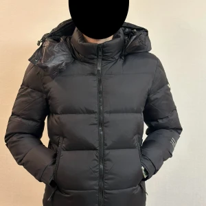 Svart dunjacka från Moncler - Helt ny svart dunjacka från Moncler med huva och dragkedja. Originalpåse och taggar medföljer.