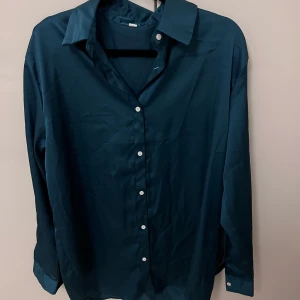 Mörkblå skjorta - Snygg mörkblå skjorta med klassisk krage och knappar framtill. Perfekt för en stilren look.