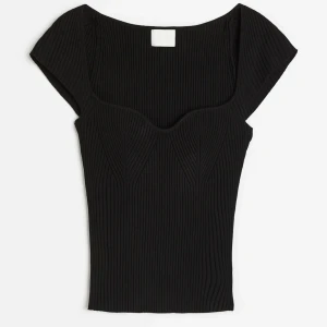 Svart ribbad topp - Snygg svart ribbad topp med korta ärmar och en smickrande passform. Perfekt för en stilren look. Strl XS och i princip slutsåld!