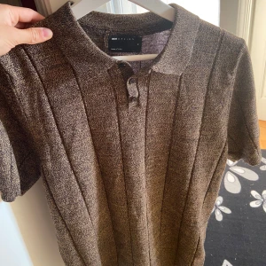 Brun pikétröja från Selected Homme - Säljer denna helt oanvända, stilrena Asos Pikén. Storlek medium men sitter som small.