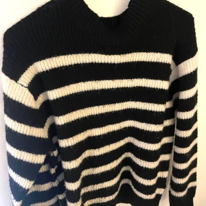 Svart och vit randig stickad tröja - Säljer en mysig svart och vit randig stickad tröja med långa ärmar. Från hm.