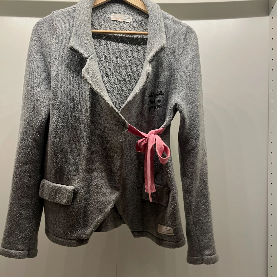 Grå kofta med rosa knytband