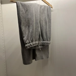 Grå ribbade mjukisbyxor - Säljer ett par grå ribbade mjukisbyxor med snörning i midjan. Perfekta för en avslappnad stil och bekväma att bära hemma eller på språng. Lite korta för mig som är 170😇