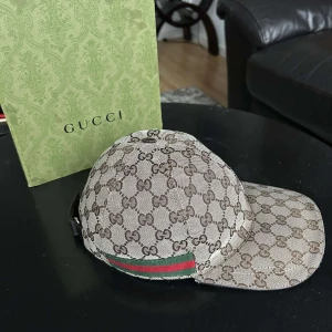 Beige keps från Gucci - Hej! Har en äkta Beige gucci keps från Gucci, som i nu läget är värt runt 6 000 kr. Kepsen kommer ej till användning och därav vill jag sälja den. (kan även byta mot en större strl M-L)  Priset är ej hugget i sten.  Vid frågor är det bara att höra av sig‼️ 